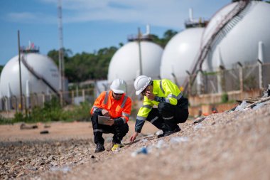 Çevre mühendisi veya işçiler, sistemlerin etkin çevre düzenlemelerini sağlamak için büyük bir endüstriyel atık su veya kirlilik izleme ve bakımı boyunca atık suyu inceleyen işçiler.