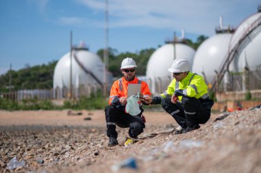 Çevre mühendisi veya işçiler, sistemlerin etkin çevre düzenlemelerini sağlamak için büyük bir endüstriyel atık su veya kirlilik izleme ve bakımı boyunca atık suyu inceleyen işçiler.