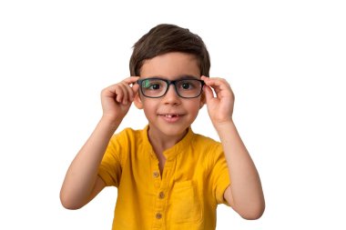 Gözlük takan mutlu çocuk portresi. Beyaz arka planda izole edilmiş. Kahverengi saçlı ve iri gözlü yakışıklı bir çocuk. Eğitim konsepti. Mutlu bir çocukluk. Okula gitme zamanı.
