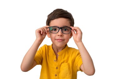 Gözlük takan mutlu çocuk portresi. Beyaz arka planda izole edilmiş. Kahverengi saçlı ve iri gözlü yakışıklı bir çocuk. Eğitim konsepti. Mutlu bir çocukluk. Okula gitme zamanı.