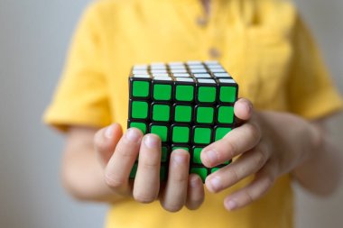 Rubik küpü bir çocuğun ellerinde, yakın plan. Eğitici bir kavram. Beyaz arkaplanda izole.