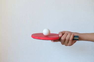Beyaz arka planda, elinde top olan masa tenisi raketi. Spor konsepti.