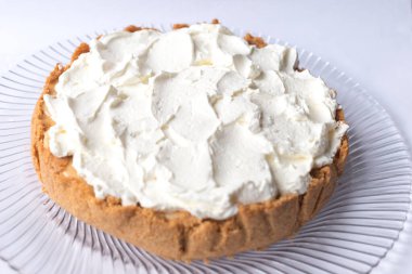 Banoffee muzlu turta ve beyaz arka planda karamel sosu ve peynir kremi. Geleneksel İngiliz pastası. Yemek hazır. Yemek pişirme konsepti.