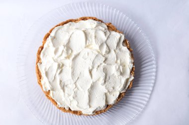 Banoffee muzlu turta ve beyaz arka planda karamel sosu ve peynir kremi. Geleneksel İngiliz pastası. Yemek hazır. Yemek pişirme konsepti.