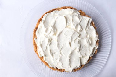 Banoffee muzlu turta ve beyaz arka planda karamel sosu ve peynir kremi. Geleneksel İngiliz pastası. Yemek hazır. Yemek pişirme konsepti.
