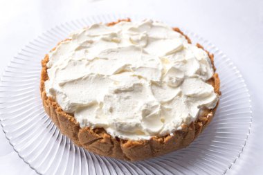 Banoffee muzlu turta ve beyaz arka planda karamel sosu ve peynir kremi. Geleneksel İngiliz pastası. Yemek hazır. Yemek pişirme konsepti.