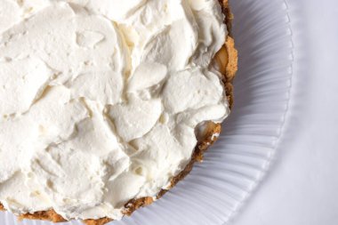 Banoffee muzlu turta ve beyaz arka planda karamel sosu ve peynir kremi. Geleneksel İngiliz pastası. Yemek hazır. Yemek pişirme konsepti.