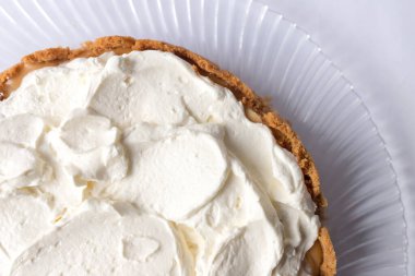 Banoffee muzlu turta ve beyaz arka planda karamel sosu ve peynir kremi. Geleneksel İngiliz pastası. Yemek hazır. Yemek pişirme konsepti.
