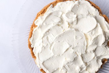 Banoffee muzlu turta ve beyaz arka planda karamel sosu ve peynir kremi. Geleneksel İngiliz pastası. Yemek hazır. Yemek pişirme konsepti.