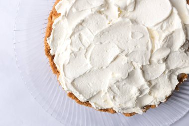 Banoffee muzlu turta ve beyaz arka planda karamel sosu ve peynir kremi. Geleneksel İngiliz pastası. Yemek hazır. Yemek pişirme konsepti.