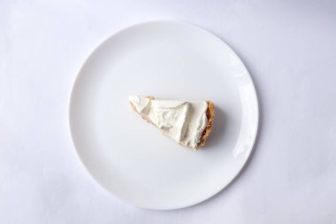 Beyaz arka planda karamel soslu ve peynirli banoffee muzlu turta. Geleneksel İngiliz pastası. Yemek hazır. Yemek pişirme konsepti.