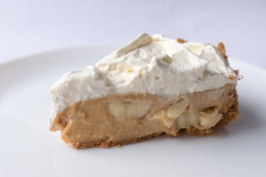 Beyaz arka planda karamel soslu ve peynirli banoffee muzlu turta. Geleneksel İngiliz pastası. Yemek hazır. Yemek pişirme konsepti.