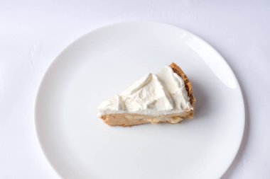 Beyaz arka planda karamel soslu ve peynirli banoffee muzlu turta. Geleneksel İngiliz pastası. Yemek hazır. Yemek pişirme konsepti