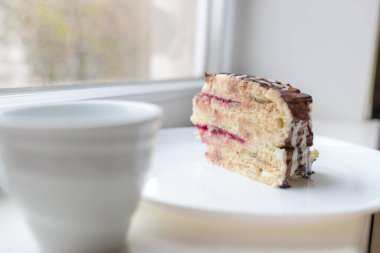 Bir parça çikolatalı Milchmadchen peynirli krema soslu ve pencerenin kenarında muz ve kirazlı. Geleneksel Alman pastası. Yemek hazır..