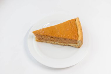 Beyaz arka planda karamel soslu bir parça balkabağı turtası. Geleneksel pasta. Yemek hazır. Yemek pişirme konsepti. Cadılar Bayramı zamanı