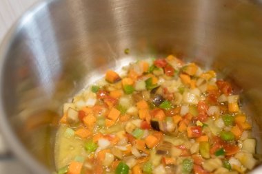 Mutfaktaki ocağın tavasında sebze çorbası var. Yemek vakti..