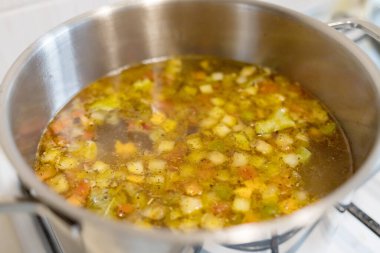 Mutfaktaki ocağın tavasında sebze çorbası var. Yemek vakti. Yemek hazır..