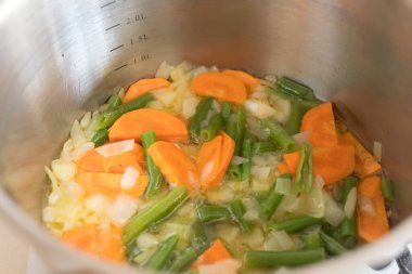 Mutfaktaki ocağın tavasında sebze çorbası var. Yemek vakti..