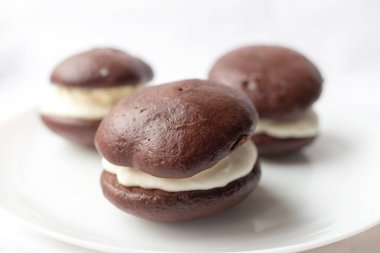 Beyaz arka planda kremalı çikolatalı kek. Siyah-beyaz, Bob, BFO. Yemek hazır. Ev yapımı pişirme..