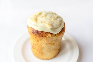 Lezzetli Paskalya Kulich pastası. Beyaz arka planda limonlu badem dolgulu, kuru üzümlü ve şekerli meyve..