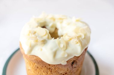 Lezzetli Paskalya Kulich pastası. Beyaz arka planda limonlu badem dolgulu, kuru üzümlü ve şekerli meyve..