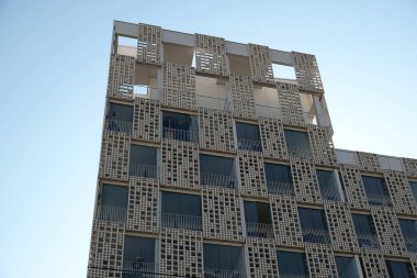 Modern beyaz açılış evinin dış cephesi. Pencerelere ve duvar dokusuna yakın plan mimari detaylar. Gayrimenkul, apartman dairesi ve ofis. Yaşayan daireler ya da ofis mimarisi.