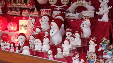 Berlin, Almanya 'daki market tezgahlarında geleneksel Noel ağacı süsleme oyuncakları. Güzel dekoratif seramik kardan adamlar, farklı şekiller ve ruh halleri.