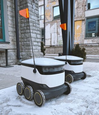 Autonomous delivery robot on Tallinn, Estonia. Estonian company developing autonomous delivery vehicles. Delivery robot waiting for order at cafe or restaurant. Technology, unmanned courier robot. 