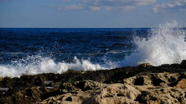 stock image Blue sea wave and white foam and splash. Stone beach on island of Malta, no sandy beach. Summer holiday border frame concept. Tropical island vacation backdrop. Tourist travel banner design template.