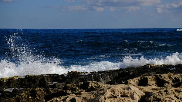 Stock image Blue sea wave and white foam and splash. Stone beach on island of Malta, no sandy beach. Summer holiday border frame concept. Tropical island vacation backdrop. Tourist travel banner design template.