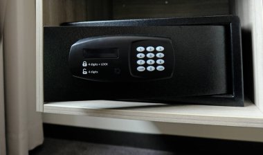 Dolaptaki metal kasa. Otelde para ya da değerli eşya saklamak için küçük bir kasa. Şifre girmek için düğmeleri olan güvenli kapıyı aç. Dolapta küçük bir kasa var. Boş kasa.