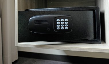 Dolaptaki metal kasa. Otelde para ya da değerli eşya saklamak için küçük bir kasa. Şifre girmek için düğmeleri olan güvenli kapıyı aç. Dolapta küçük bir kasa var. Boş kasa.