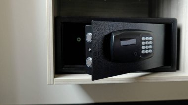 Dolaptaki metal kasa. Otelde para ya da değerli eşya saklamak için küçük bir kasa. Şifre girmek için düğmeleri olan güvenli kapıyı aç. Dolapta küçük bir kasa var. Boş kasa.