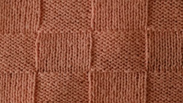パターンで編まれたセーターの断片のビデオ トップビュー クローズアップ 手作り編みウールまたは綿織物の質 珍しい抽象編まれたチェスパターン背景テクスチャ — ストック動画