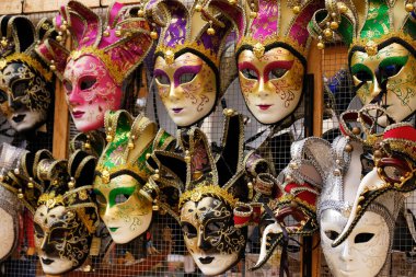 Venedik, İtalya 'da hediyelik eşya dükkanında raflarda geleneksel Venedik maskeleri. Çeşitli renklerde güzel karnaval maskeleri. Karnaval için otantik ve orijinal Venedik tam yüz maskeleri.