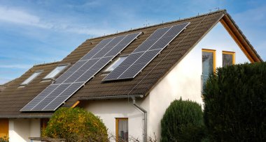 Home solar panel. Alternative energy is used for heating and water heating. Eco-friendly alternative energy for house. Residential family house suburban. Brown tile roof of home with solar panels.  clipart