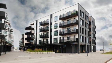 Şehrin yeni bir bölgesindeki modern evin dışında. Pencerelere yakın çekim ve cam balkonların mimari ayrıntıları. Gayrimenkul, konut ve ofis mimarisi.