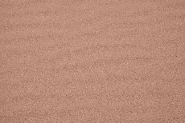 Background made of Wavy desert sand texture. Fine beach sand. Color Of The Year 2025 - Mocha Mousse