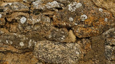 Kaba ve pürüzlü yüzeyi olan bej taştan duvar dokusu. Pürüzsüz, çatlak yüzey. Farklı şekillerde eski bir kale duvarı. Tarafsız renklerde desen. Asgari, şık, eğilim konsepti.