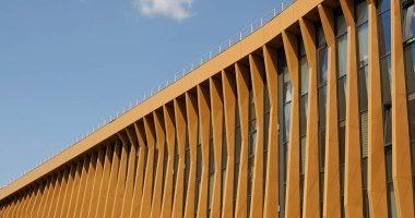 Terracotta yüzgeçleri modern binada çarpıcı bir cephe oluşturur. Çağdaş şehir mimarisi ve sürdürülebilir inşaat uygulamaları. Emlak, konut daireleri ve ofis mimarisi.