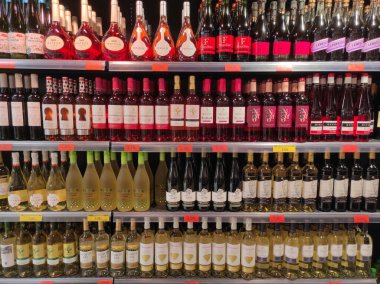 İspanya 'nın Malaga kentindeki süpermarket rafında 1 Ocak 2024 tarihli beyaz ve gül şarabı şişeleri. Modern perakende satış ortamı ve tüketim, ticaret, alışveriş ve alkollü içecekler için ideal.
