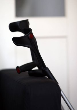 Karanlık bir yüzeyde dinlenen şık ve şık bir çift koltuk değneği modern tasarım estetiğini ön plana çıkarıyor.