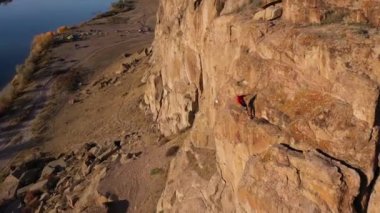 Man Climber, Multi-pitch 'ta bir dayanaktan zincire vuruyor. Tamgaly Tas, Kazakistan 'da kaya tırmanışı. Hava görüntüsü. İHA İleri Uçar, Eğilir