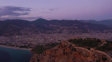 Akşam Alacakaranlığı 'ndaki Alanya Şehri ve Kalesi. Hava görüntüsü. Türk Rivierası. Hindi. İnsansız Hava Aracı Yana ve Yukarı Uçar