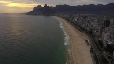 Rio de Janeiro City. Ipanema Beach and Atlantic Ocean at Sunset. Aerial View. Brazil. Drone Flies Forward, Tilt Up. Reveal Shot