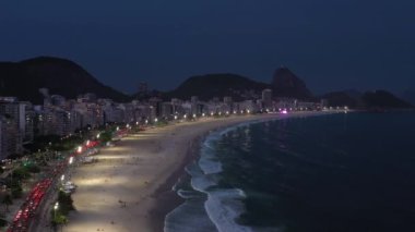 Rio de Janeiro City at Night. Copacabana Beach and Atlantic Ocean. Evening Twilight. Blue Hour. Aerial View. Brazil. Drone Flies Forward over Beach