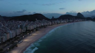 Rio de Janeiro City at Morning Twilight. Copacabana Beach and Atlantic Ocean. Blue Hour. Aerial View. Brazil. Drone Flies Forward, Tilt Up. Reveal Shot