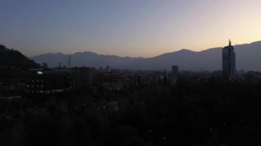 Santiago City at Morning Twilight and Andes Mountains. Blue Hour. Aerial View. Chile. Drone Flies Upwards and Forward