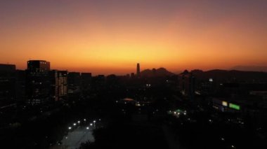 Sunset 'te parlayan Santiago City silueti. Hava görüntüsü. Akşam Alacakaranlığı. Mavi Saat. Las Condes Komünü. Şili. Drone Yukarı Uçuyor