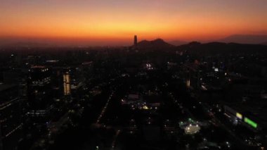 Sunset 'te parlayan Santiago City silueti. Hava görüntüsü. Akşam Alacakaranlığı. Mavi Saat. Las Condes Komünü. Şili. Drone İleri Uçuyor, Eğil. Görüntü Görüntüsü